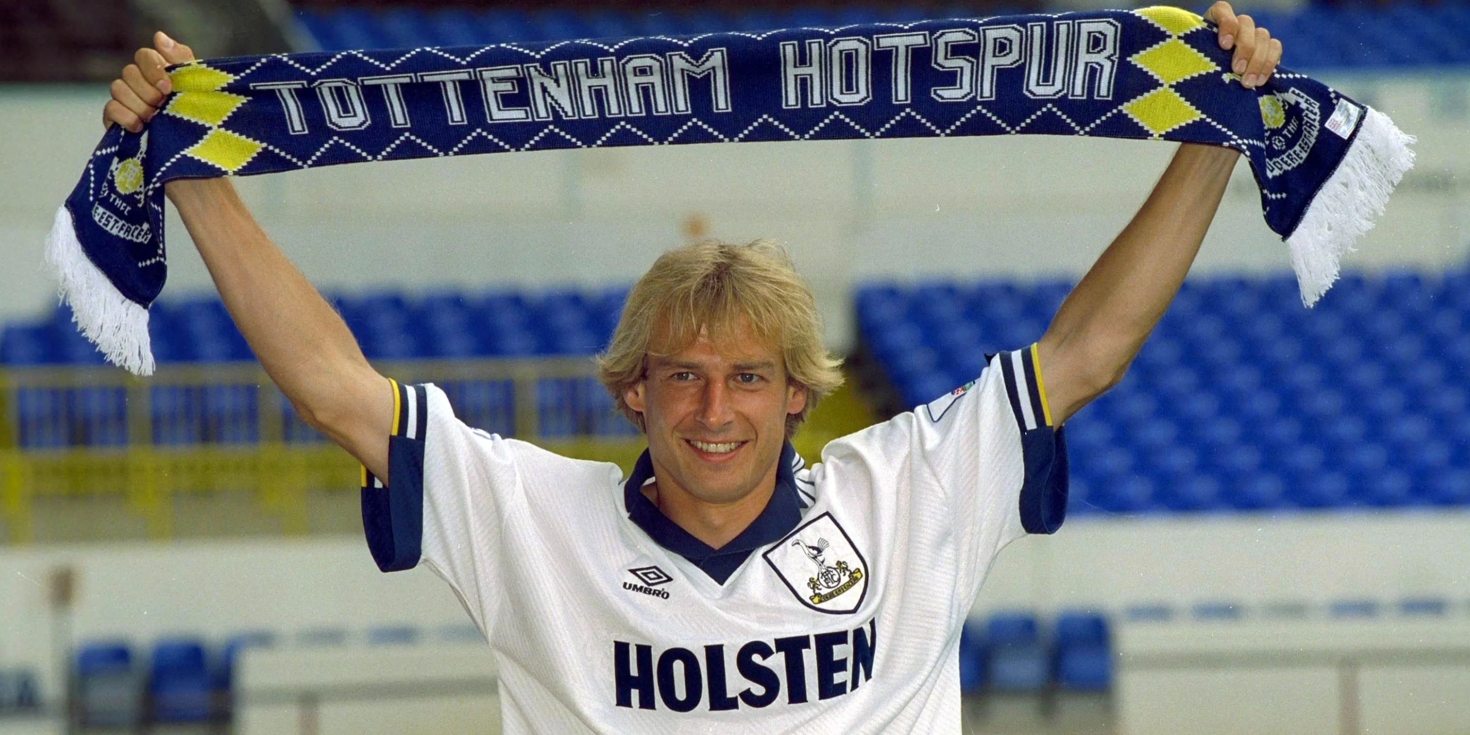 Jurgen Klinsmann giơ chiếc khăn Tottenham sau khi ký hợp đồng với câu lạc bộ