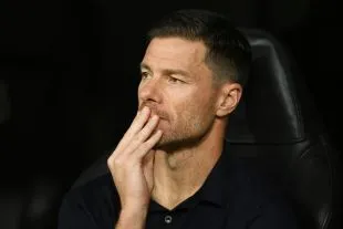 Xabi Alonso theo dõi trận đấu; minh họa quyền lợi thể thao và tài chính của các CLB lớn trong việc tái chiêu mộ cầu thủ trẻ.